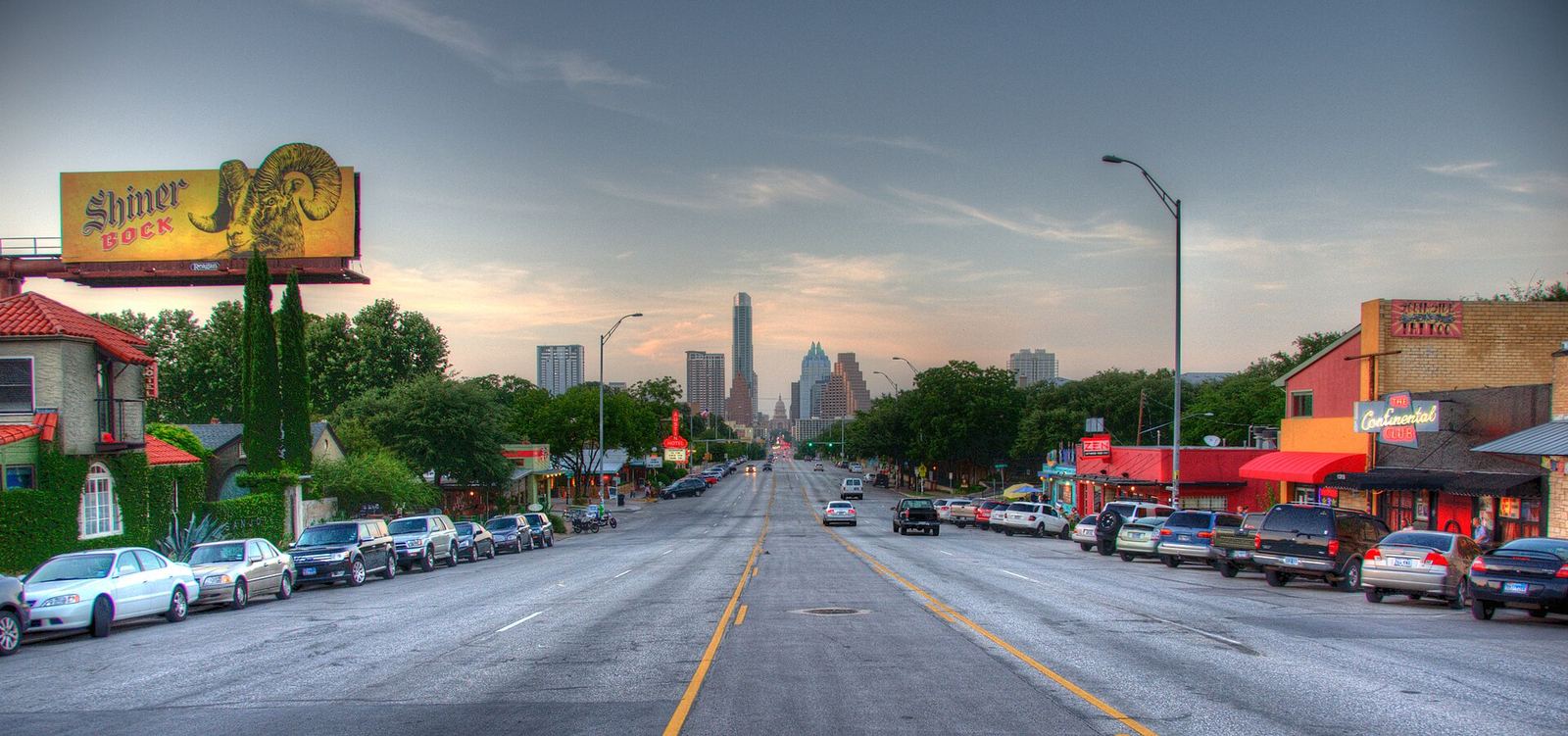South Congress Avenue in Austin lined with shops and parked cars, leading toward the downtown skyline
