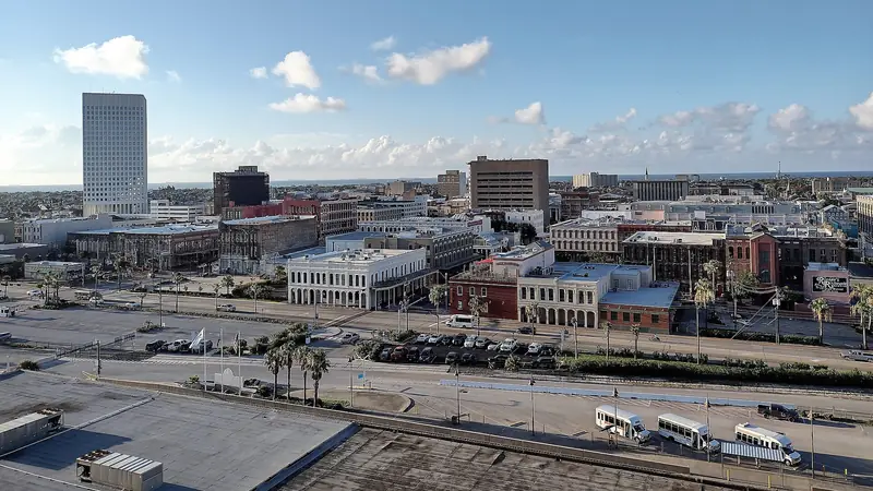 Downtown Galveston rooftops and historic buildings seen from above the harbor side, under a blue sky