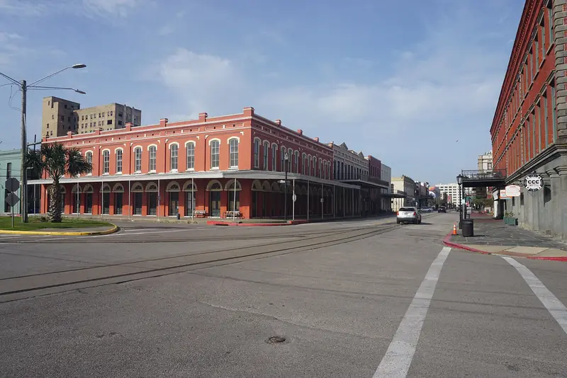 Historic red brick commercial buildings lining a street in Galveston's Strand Historic District