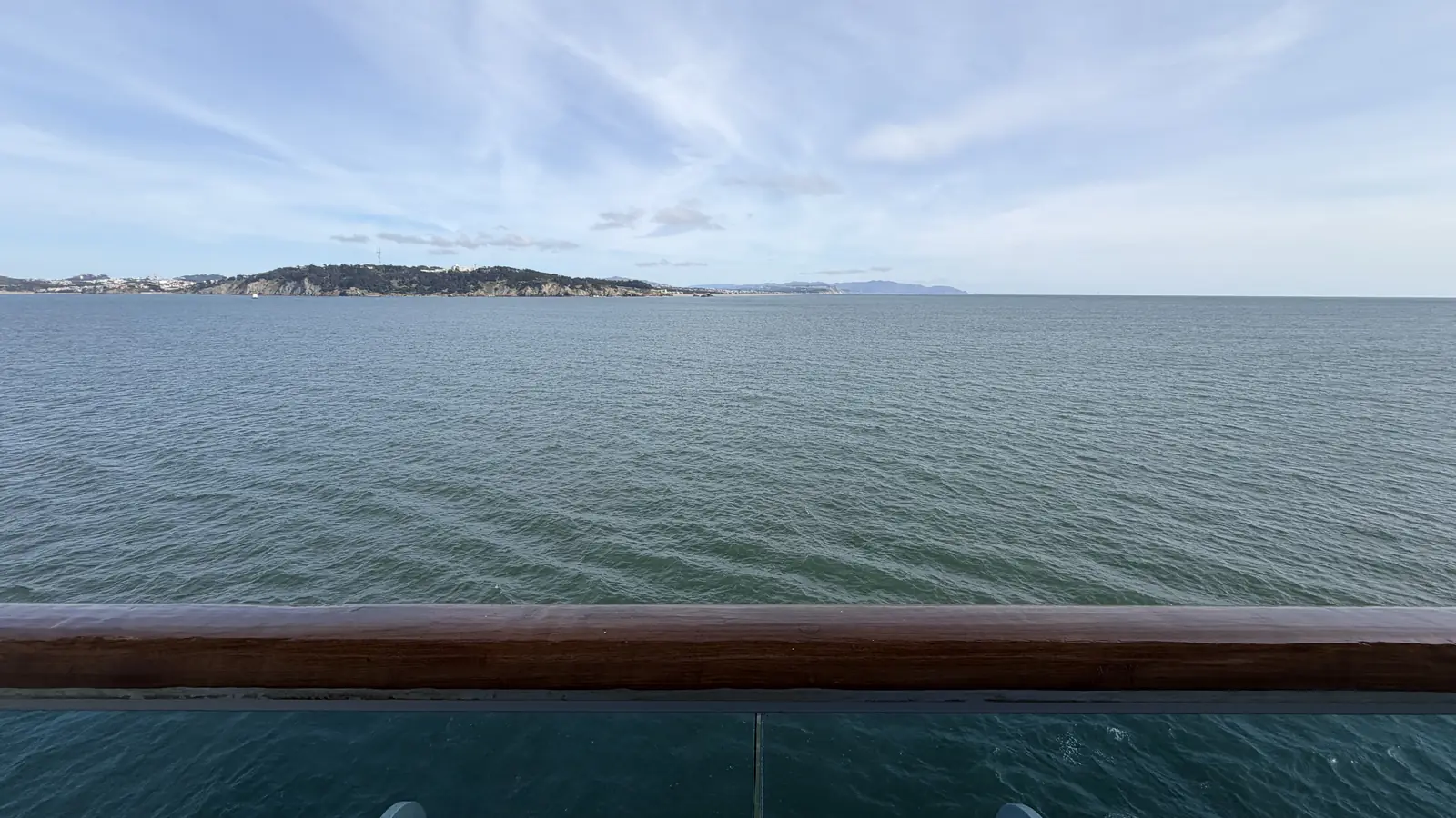 View of the open ocean from a cruise cabin balcony railing
